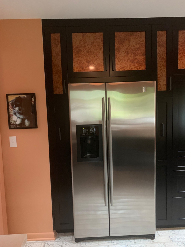 Inspiration for a small transitional u-shaped ceramic tile and multicolored floor enclosed kitchen remodel in Indianapolis with a double-bowl sink, recessed-panel cabinets, black cabinets, quartz countertops, gray backsplash, ceramic backsplash, stainless steel appliances, a peninsula and gray countertops