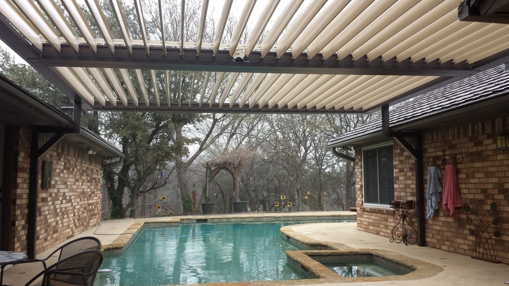This is an example of a mid-sized country backyard patio in Dallas with concrete slab and a pergola.