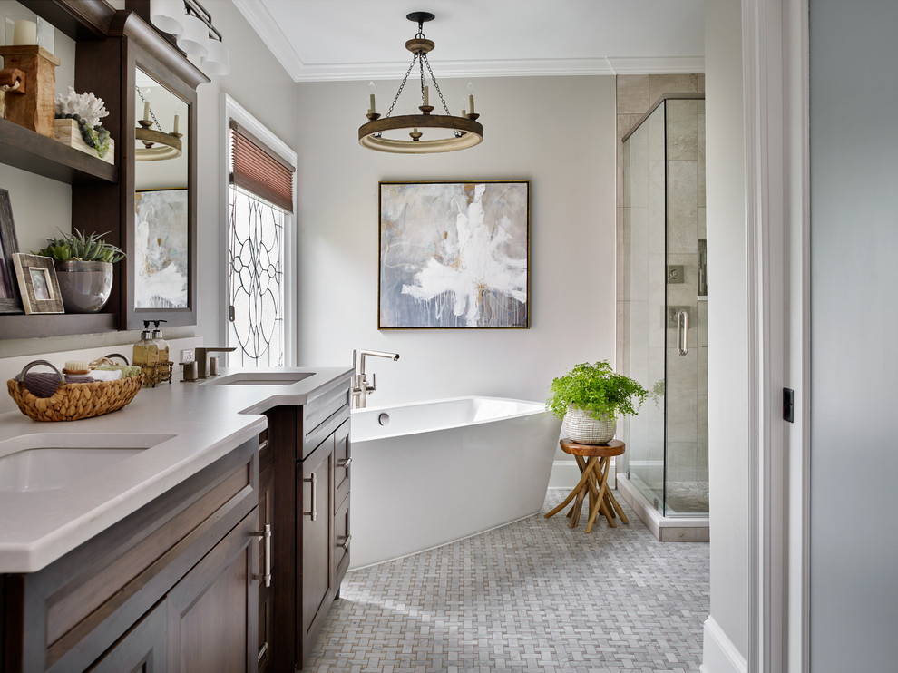 Design ideas for a mid-sized transitional master bathroom in Atlanta with raised-panel cabinets, medium wood cabinets, a freestanding tub, a corner shower, a one-piece toilet, gray tile, mosaic tile, grey walls, marble floors, an undermount sink and engineered quartz benchtops.