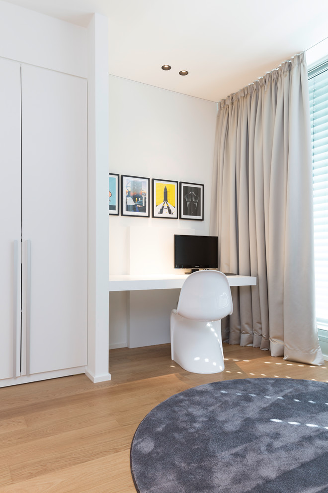 Jugendzimmer mit Arbeitsecke, weißer Wandfarbe, braunem Holzboden und braunem Boden in Cologne