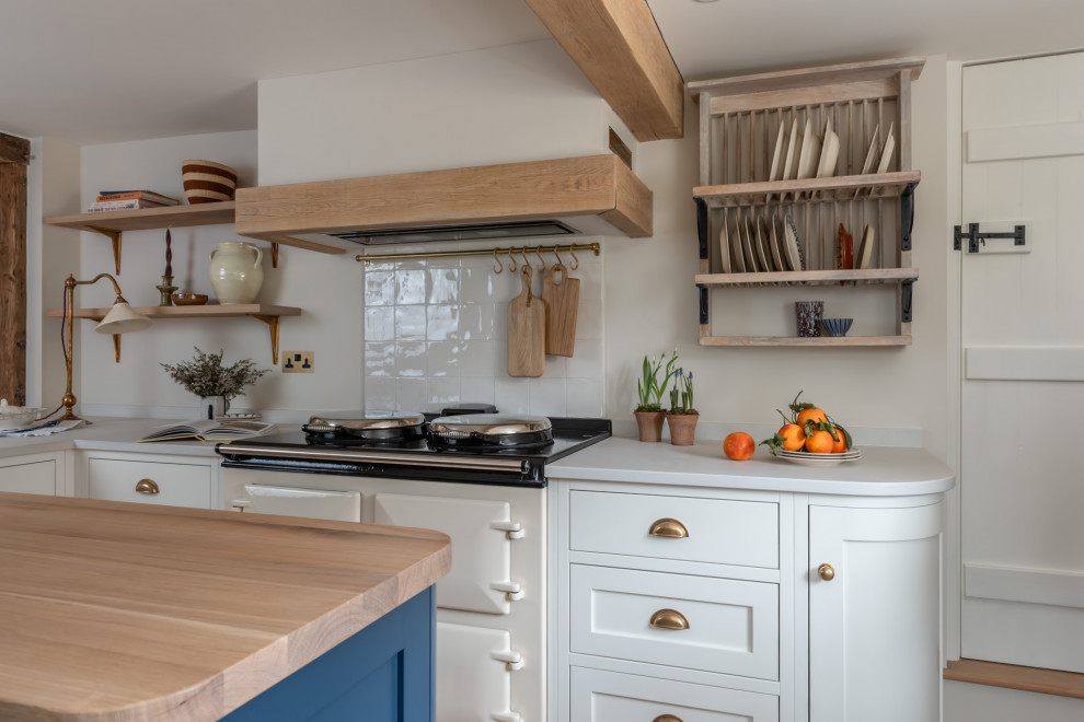 Farmhouse kitchen in Surrey with shaker cabinets, white cabinets, white splashback, an island and white worktops.