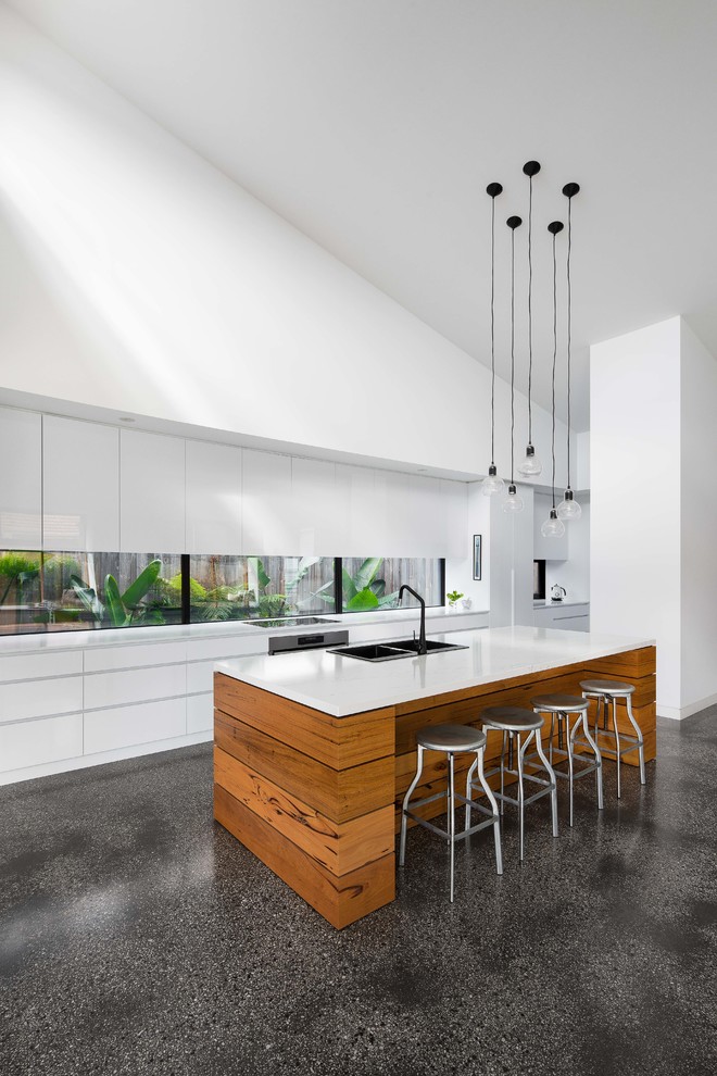 Design ideas for a mid-sized contemporary galley kitchen in Melbourne with flat-panel cabinets, white cabinets, marble benchtops, white splashback, concrete floors, with island, grey floor, white benchtop, a double-bowl sink, window splashback and stainless steel appliances.
