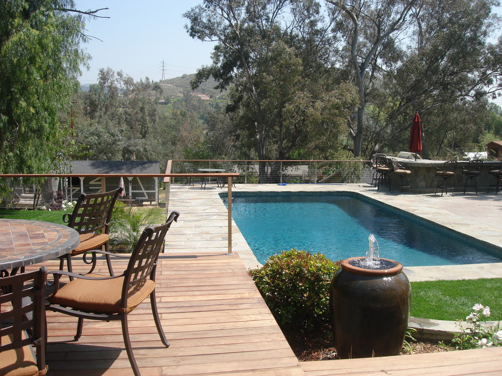 Design ideas for an expansive traditional backyard rectangular natural pool in Los Angeles with a water feature and stamped concrete.
