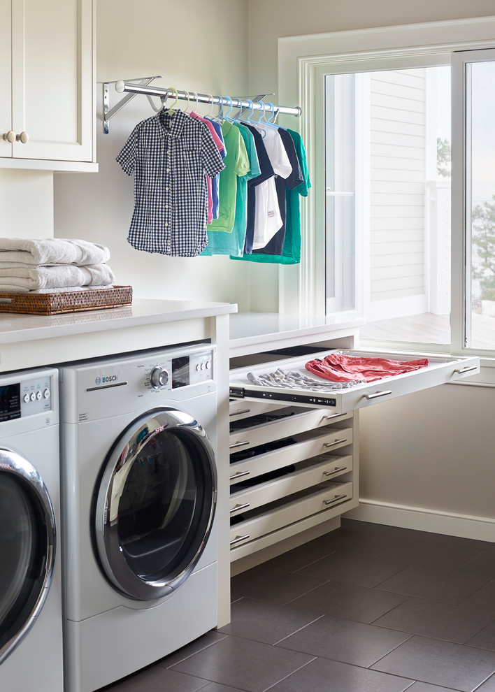 Design ideas for a beach style dedicated laundry room in Boston with white cabinets, grey walls, a side-by-side washer and dryer, grey floor, white benchtop and shaker cabinets.