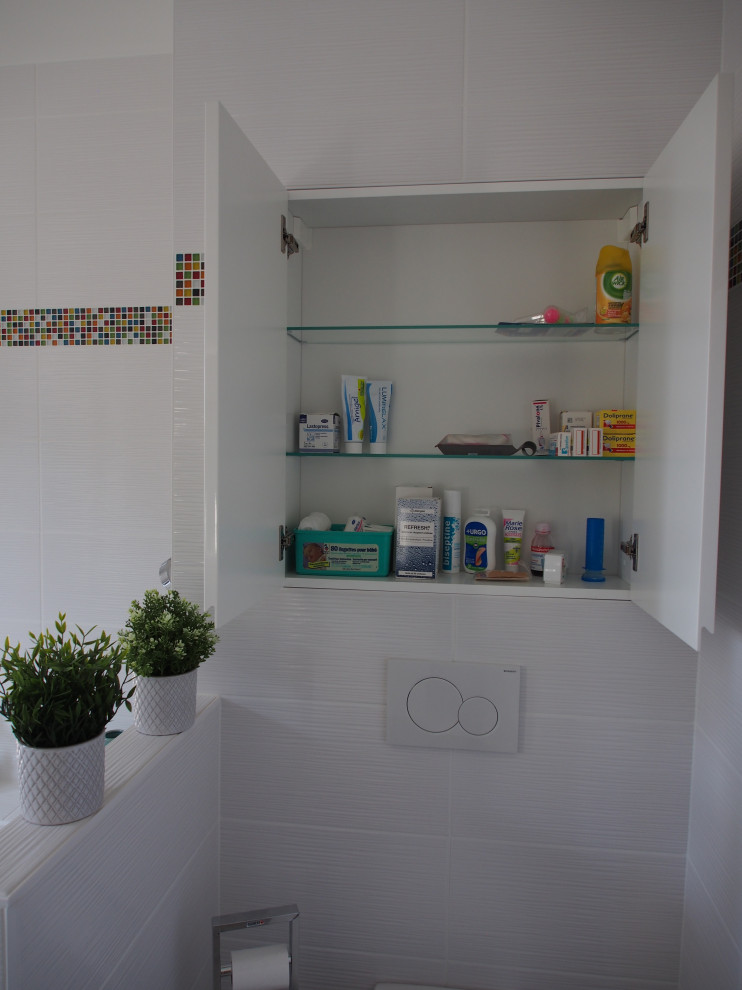 Inspiration for a mid-sized contemporary master bathroom in Nantes with flat-panel cabinets, turquoise cabinets, an undermount tub, a curbless shower, a wall-mount toilet, white tile, ceramic tile, white walls, ceramic floors, a console sink, solid surface benchtops, an open shower and white benchtops.