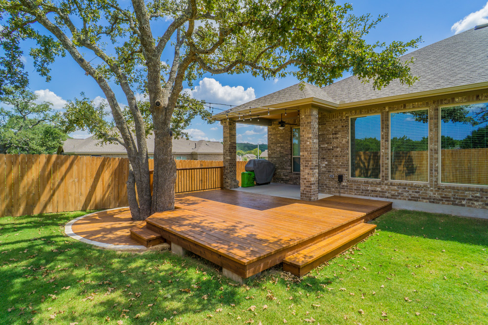 Inspiration for a mid-sized rustic backyard deck remodel in Austin with a roof extension