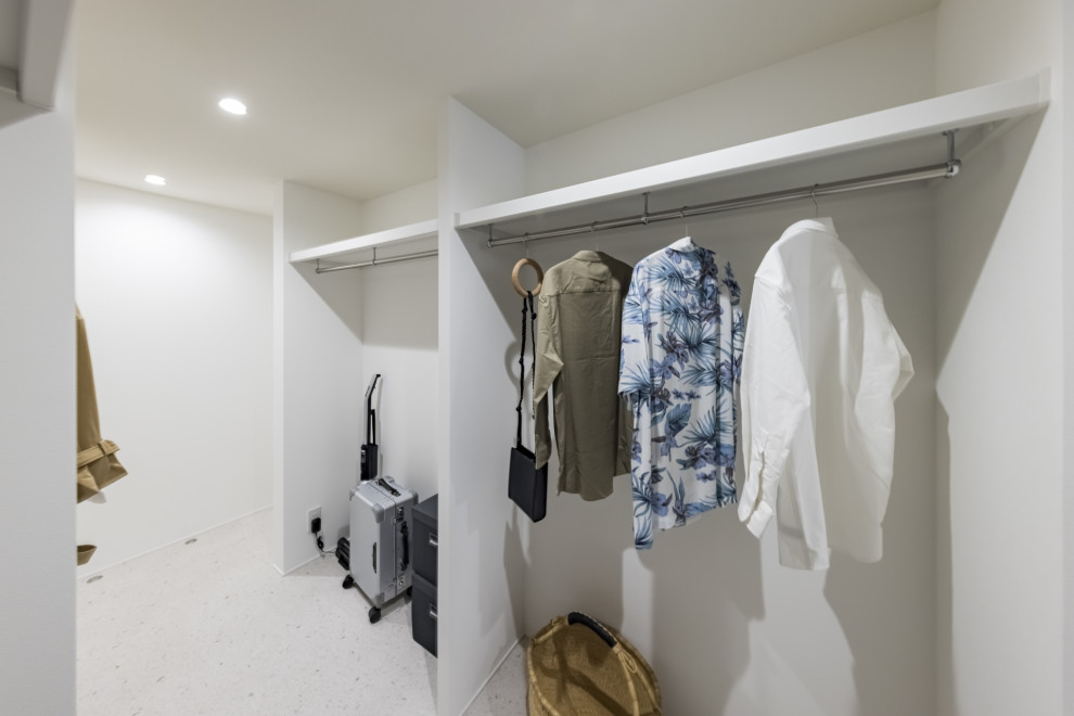 Modelo de armario vestidor unisex clásico renovado con armarios abiertos, puertas de armario blancas, suelo vinílico, suelo blanco y papel pintado