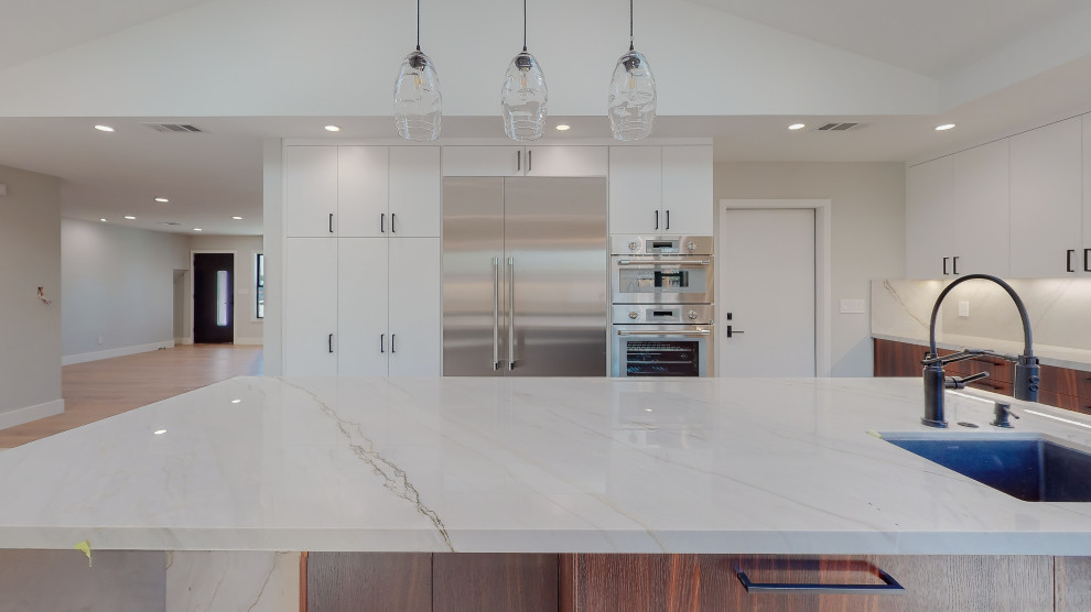 This is an example of a contemporary u-shaped kitchen/diner in San Francisco with a submerged sink, raised-panel cabinets, dark wood cabinets, marble worktops, multi-coloured splashback, marble splashback, coloured appliances, an island, white floors, multicoloured worktops and exposed beams.