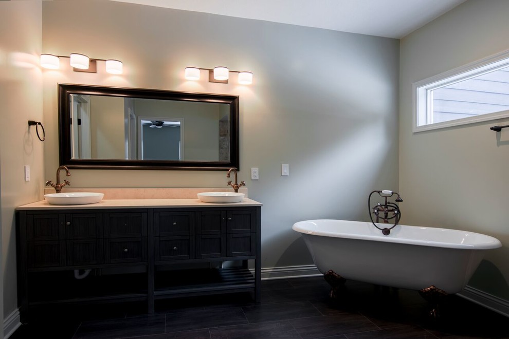 Inspiration for a country master bathroom in Columbus with furniture-like cabinets, dark wood cabinets, a claw-foot tub, a corner shower, a one-piece toilet, grey walls, dark hardwood floors, a vessel sink and engineered quartz benchtops.