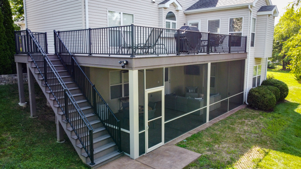 This is an example of a mid-sized backyard and first floor deck in St Louis with with privacy feature and metal railing.
