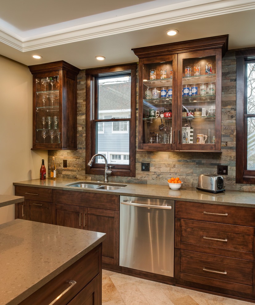 Mid-sized transitional l-shaped travertine floor eat-in kitchen photo with an undermount sink, recessed-panel cabinets, dark wood cabinets, quartz countertops, multicolored backsplash, stone slab backsplash, stainless steel appliances and an island