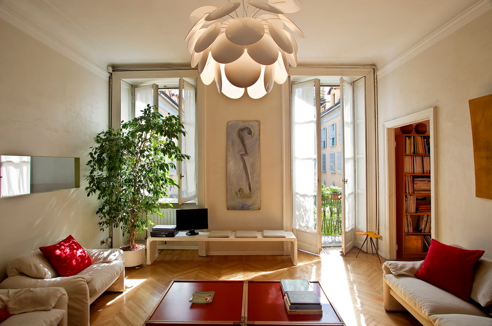 Inspiration for a large modern enclosed living room in Milan with beige walls, light hardwood floors and a freestanding tv.