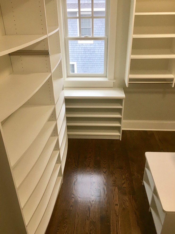 Mid-sized transitional gender-neutral built-in wardrobe in New York with shaker cabinets, white cabinets and medium hardwood floors.