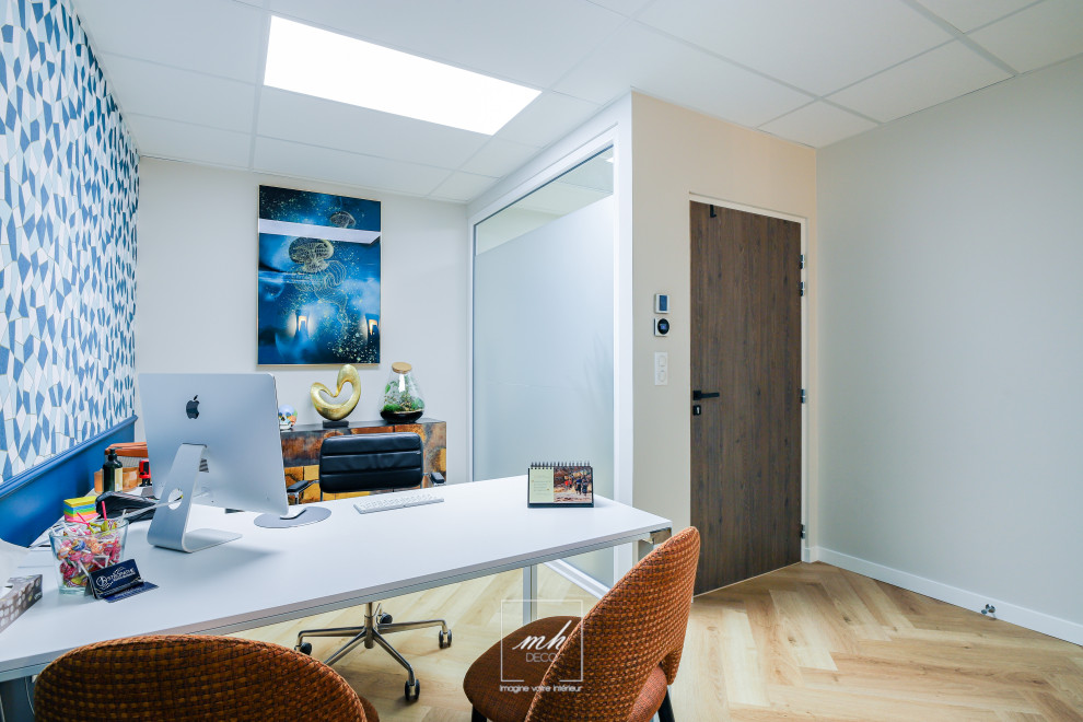 Mid-sized transitional study room in Lyon with blue walls, laminate floors, a freestanding desk, blue floor and wallpaper.