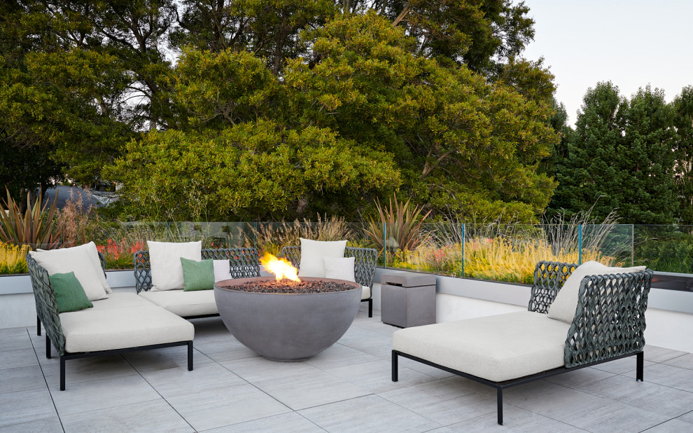 This is an example of a contemporary patio in San Francisco with a fire feature, tile and no cover.