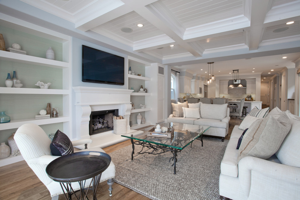 Inspiration for a large beach style open concept family room in Orange County with light hardwood floors, a standard fireplace, a wall-mounted tv, multi-coloured walls and a wood fireplace surround.
