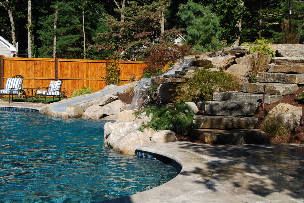 Water slide - mid-sized rustic backyard stone and kidney-shaped natural water slide idea in Boston
