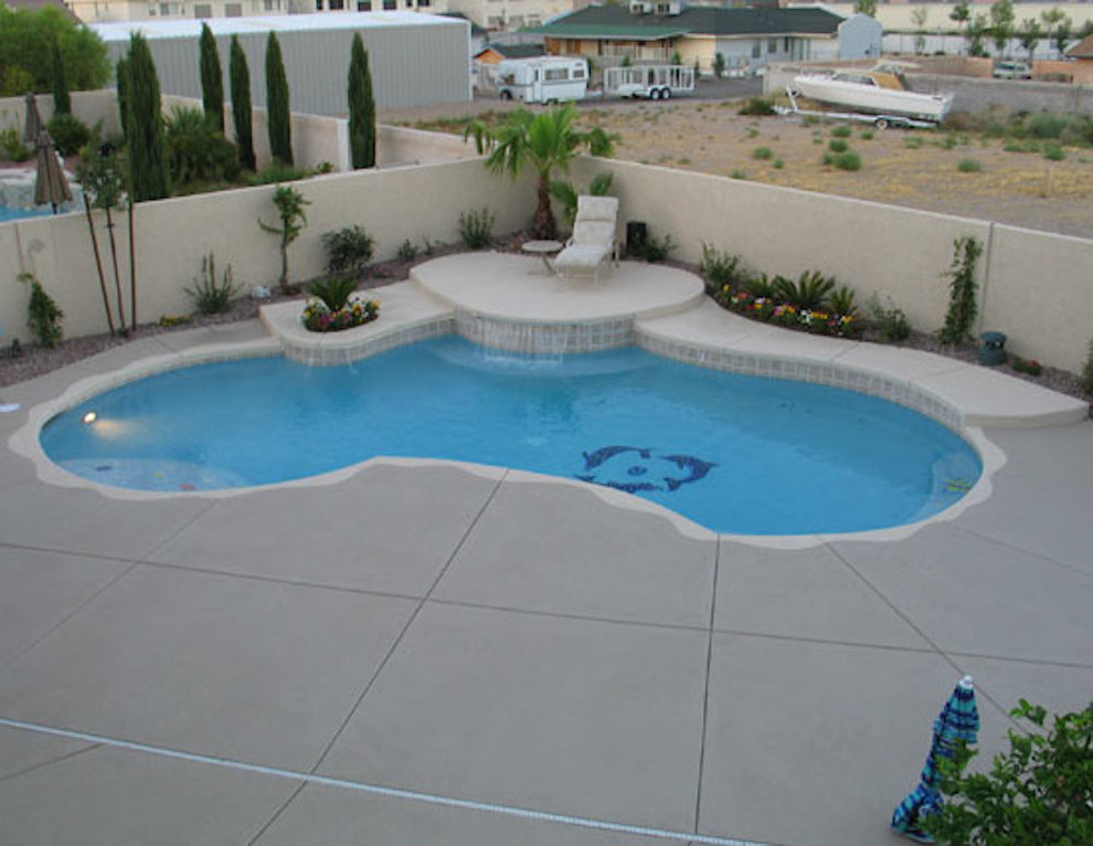 This is an example of a large backyard round natural pool in Las Vegas with a water feature.