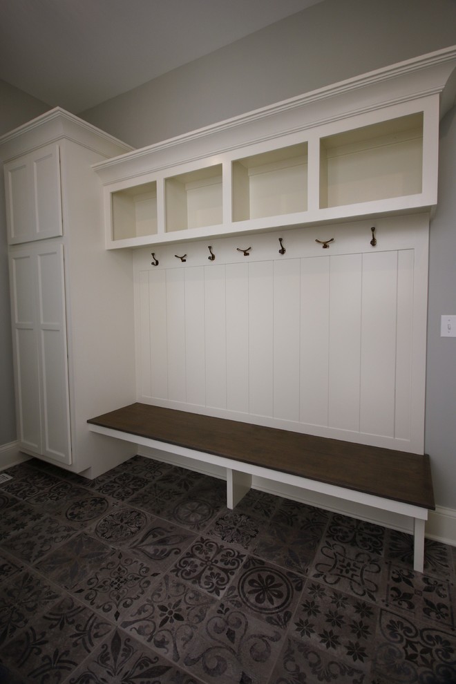 This is an example of a small arts and crafts mudroom in Chicago with grey walls, ceramic floors, a single front door, a white front door and grey floor.