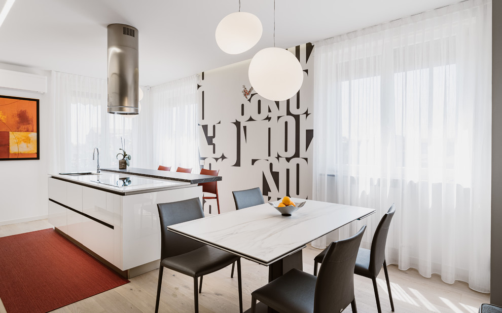 Photo of a large modern galley open plan kitchen in Milan with a double-bowl sink, glass-front cabinets, white cabinets, solid surface benchtops, white splashback, glass sheet splashback, stainless steel appliances, light hardwood floors, with island, beige floor and multi-coloured benchtop.