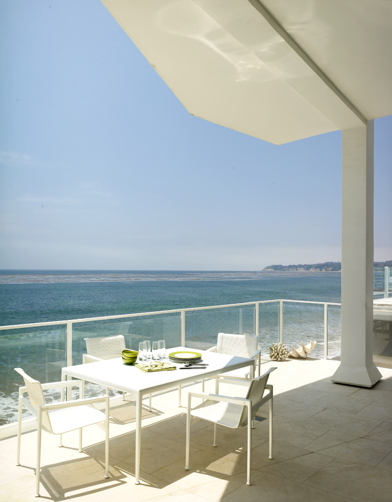 Inspiration for a beach style balcony in Los Angeles with a roof extension.