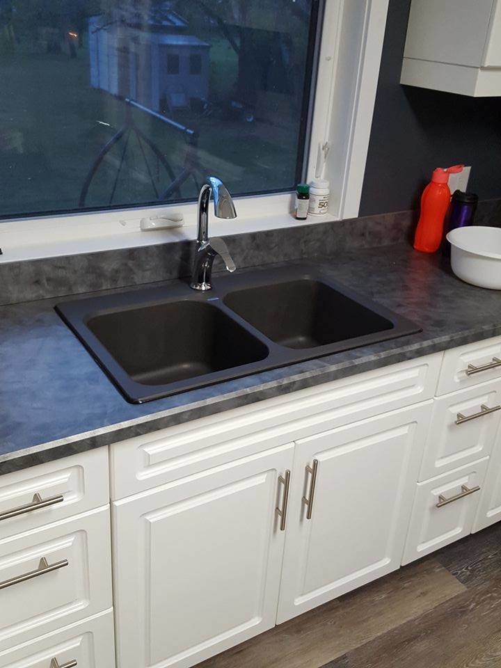 Inspiration for a transitional medium tone wood floor and brown floor kitchen remodel with a drop-in sink, raised-panel cabinets, white cabinets, white appliances and laminate countertops