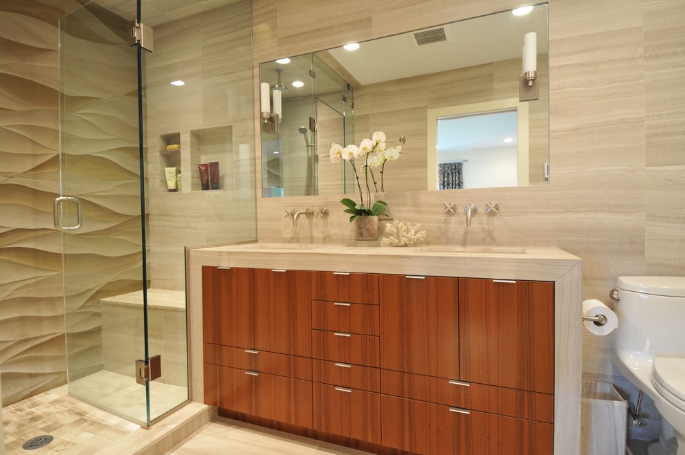 Photo of a mid-sized contemporary master wet room bathroom in Boston with flat-panel cabinets, medium wood cabinets, beige tile, a one-piece toilet, cement tile, grey walls, limestone floors, an undermount sink, limestone benchtops, grey floor, a hinged shower door and beige benchtops.