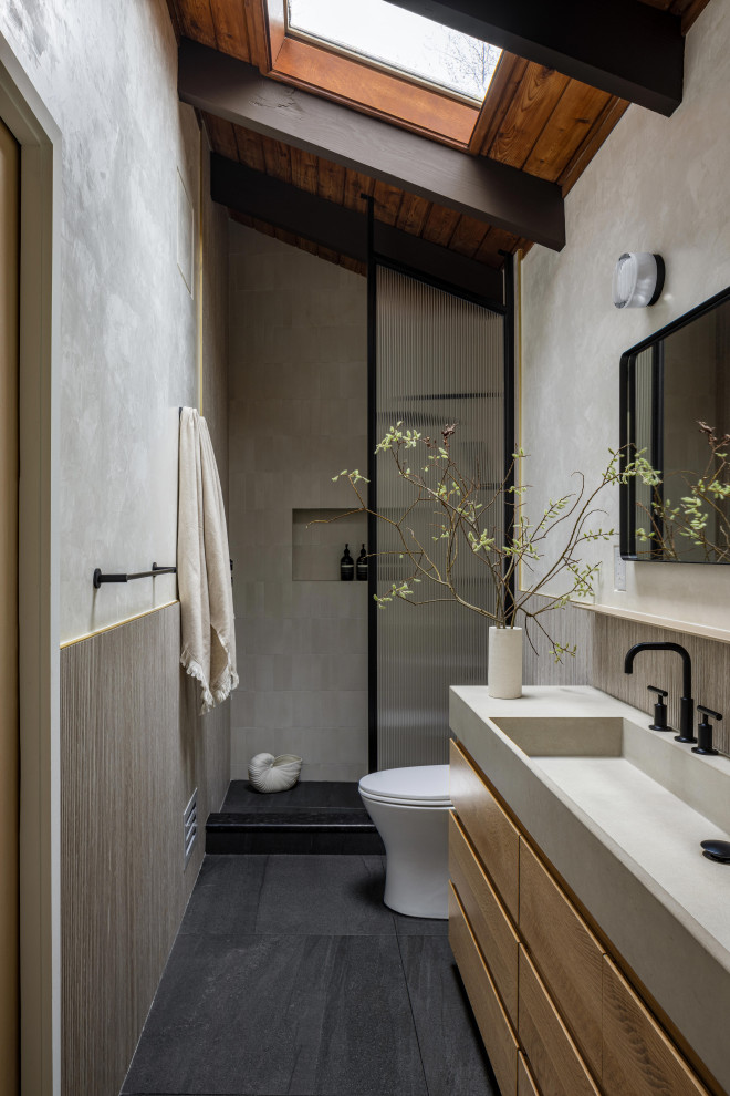 Design ideas for a small contemporary master bathroom in New York with flat-panel cabinets, light wood cabinets, an open shower, a one-piece toilet, beige walls, slate floors, an integrated sink, concrete benchtops, black floor, a shower curtain, grey benchtops, a double vanity and exposed beam.