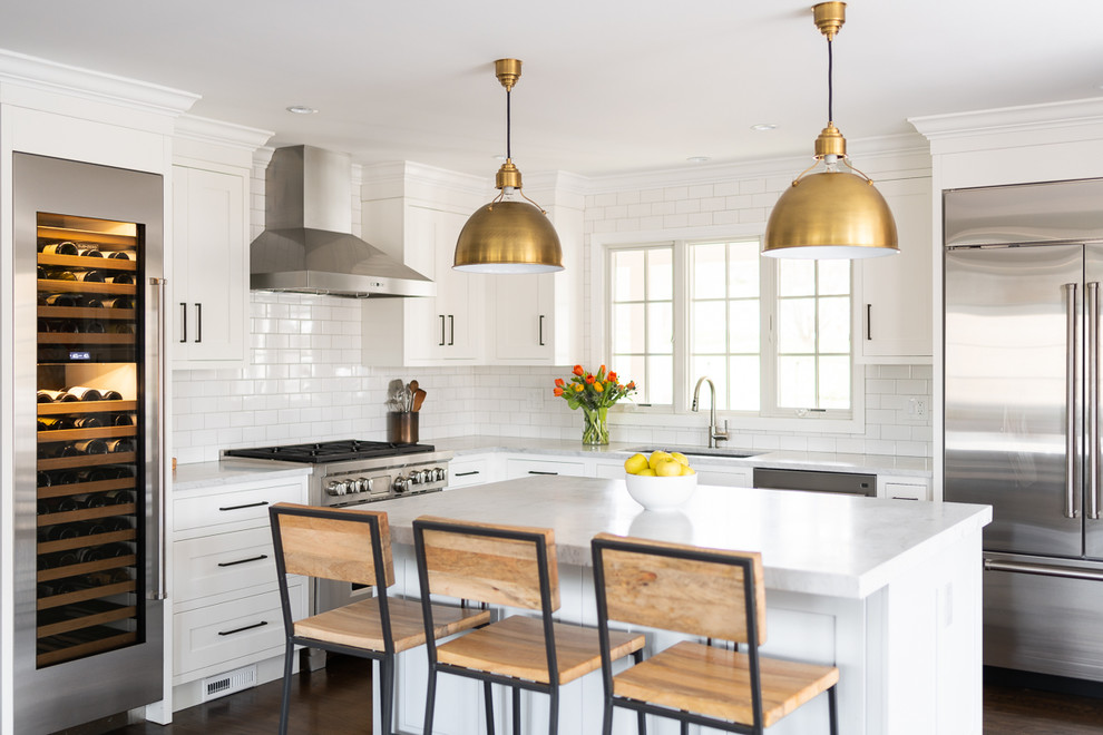 Inspiration for a large transitional l-shaped kitchen in New York with an undermount sink, shaker cabinets, white cabinets, marble benchtops, white splashback, subway tile splashback, stainless steel appliances, with island, brown floor, white benchtop and dark hardwood floors.