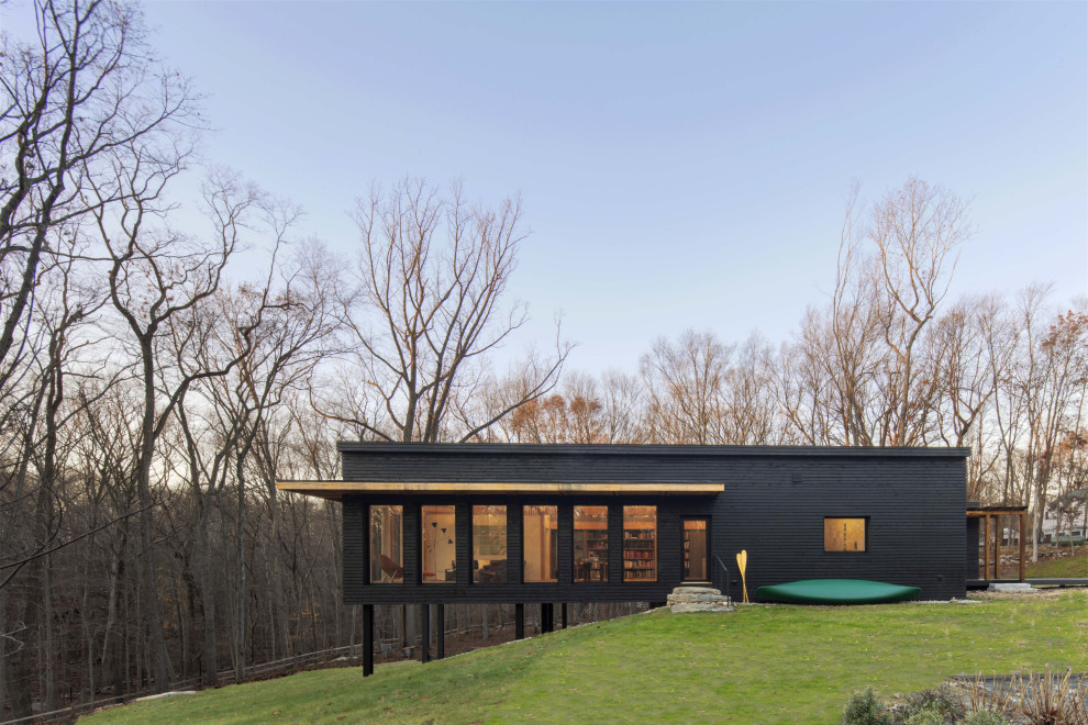 Cette image montre une façade de maison marron chalet en bardage à clin de taille moyenne et de plain-pied avec un toit plat.