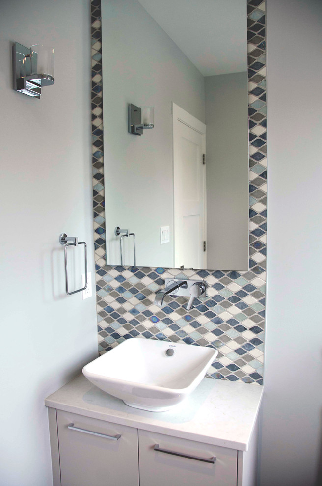 Photo of a transitional bathroom in Vancouver with flat-panel cabinets, white cabinets, a one-piece toilet, multi-coloured tile, glass tile, blue walls, dark hardwood floors, a vessel sink and granite benchtops.