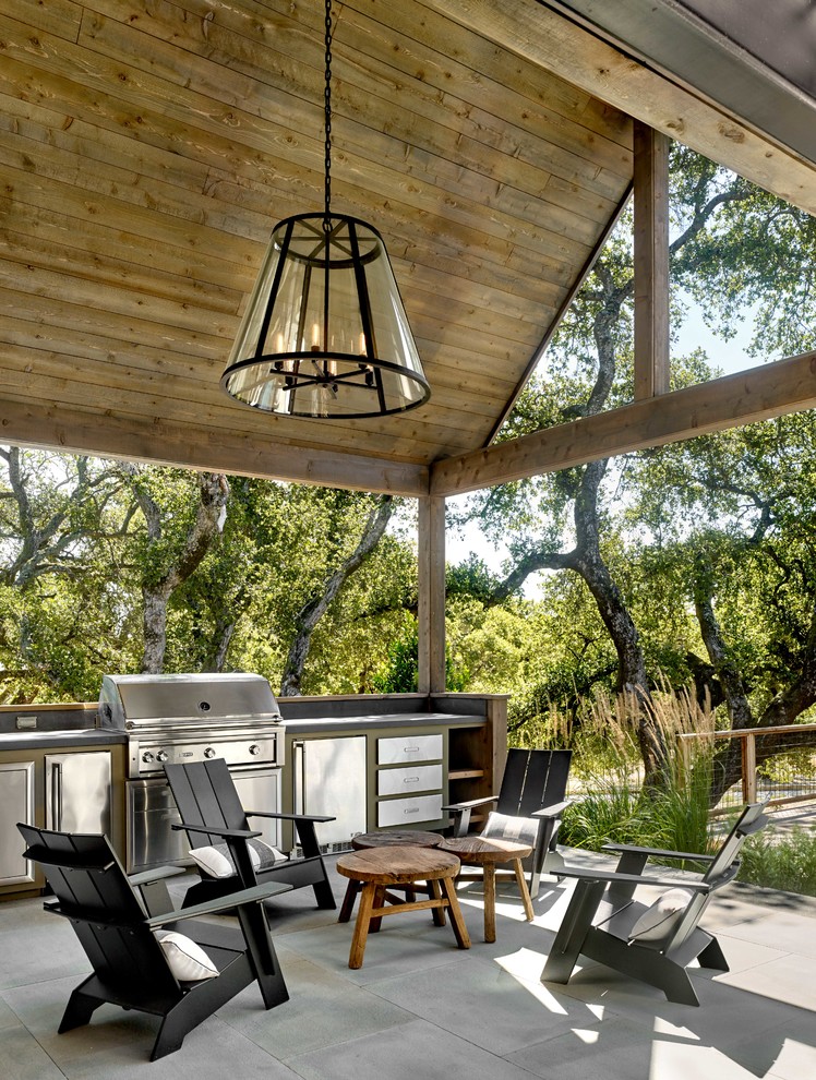 This is an example of a country patio in San Francisco with an outdoor kitchen and a roof extension.