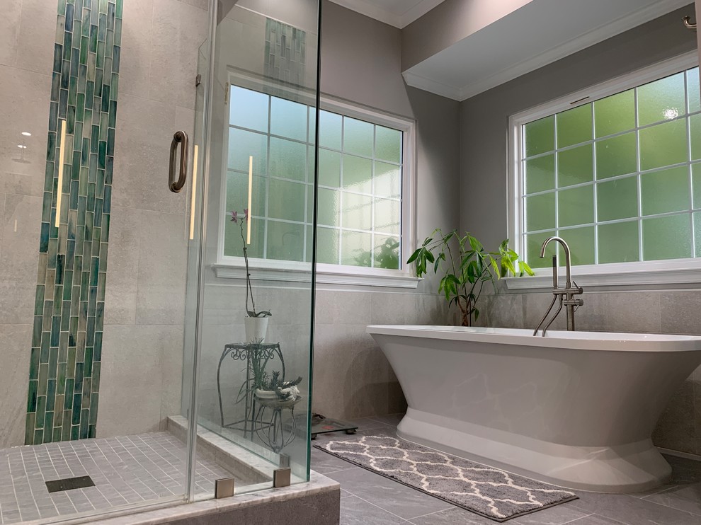 Photo of a mid-sized modern master bathroom in DC Metro with furniture-like cabinets, white cabinets, a freestanding tub, a corner shower, a one-piece toilet, gray tile, porcelain tile, grey walls, porcelain floors, an undermount sink, granite benchtops, grey floor, a hinged shower door and grey benchtops.