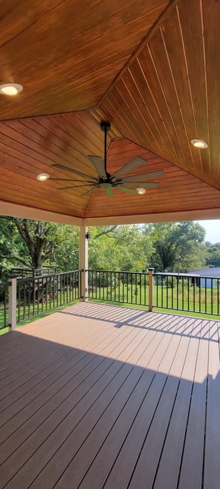 Trendy ground level metal railing deck photo with a roof extension