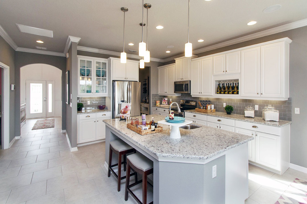Design ideas for a large transitional l-shaped eat-in kitchen in Orlando with an undermount sink, white cabinets, grey splashback, subway tile splashback, stainless steel appliances, ceramic floors and with island.