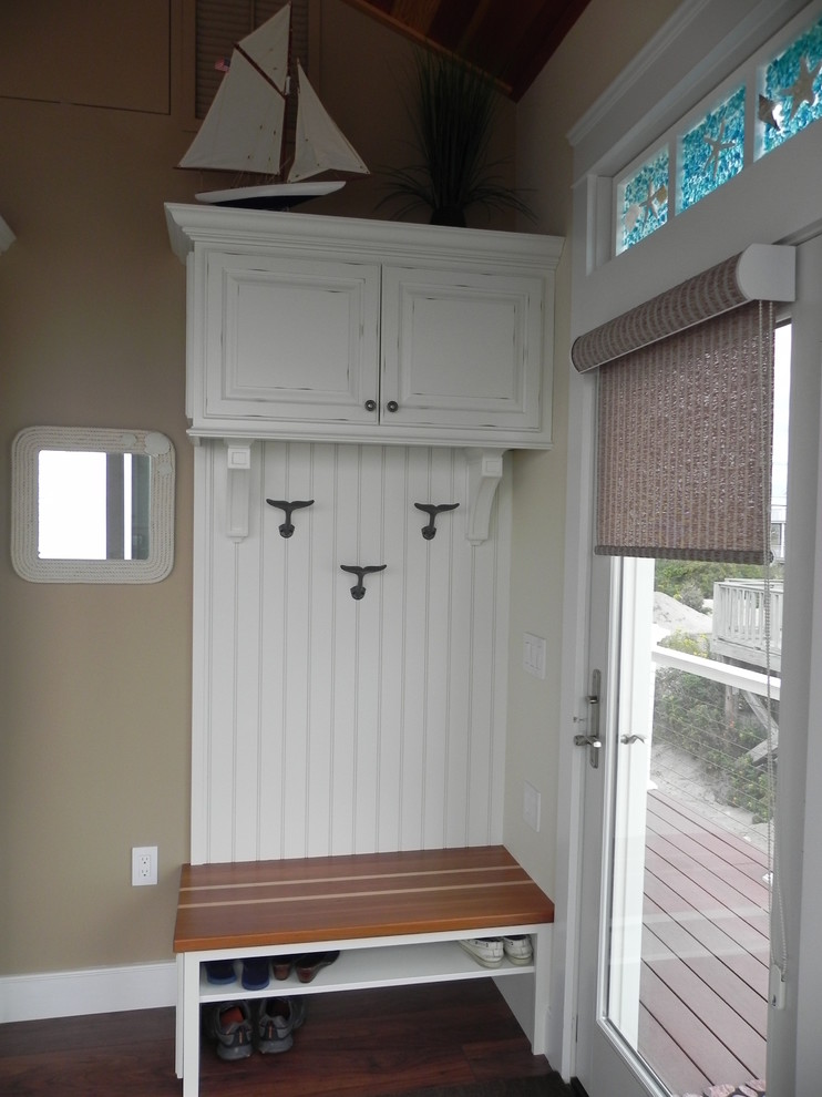 This is an example of a small beach style mudroom in Providence with brown walls, dark hardwood floors, a single front door and a glass front door.