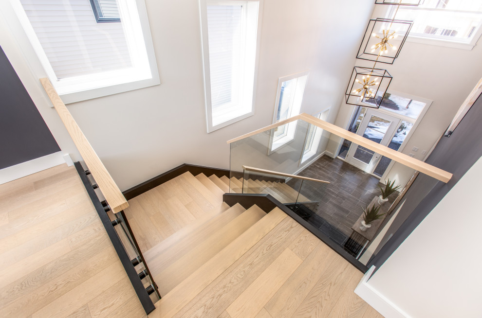 Inspiration for a modern wood glass railing staircase in Vancouver with wood risers.