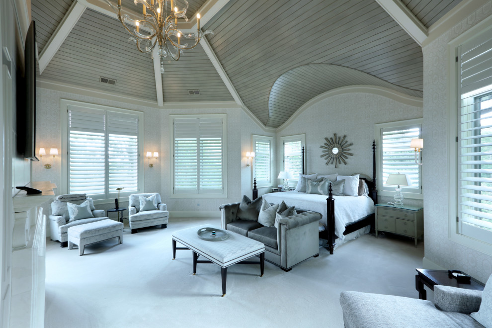 Großes Klassisches Hauptschlafzimmer mit beiger Wandfarbe, Teppichboden, Kamin, weißem Boden, gewölbter Decke und Tapetenwänden in Grand Rapids