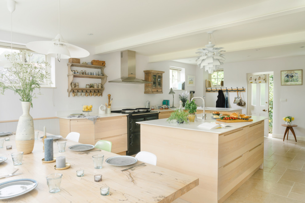 Inspiration for a medium sized contemporary u-shaped kitchen/diner with a built-in sink, flat-panel cabinets, light wood cabinets, soapstone worktops, black appliances, an island, beige floors and white worktops.