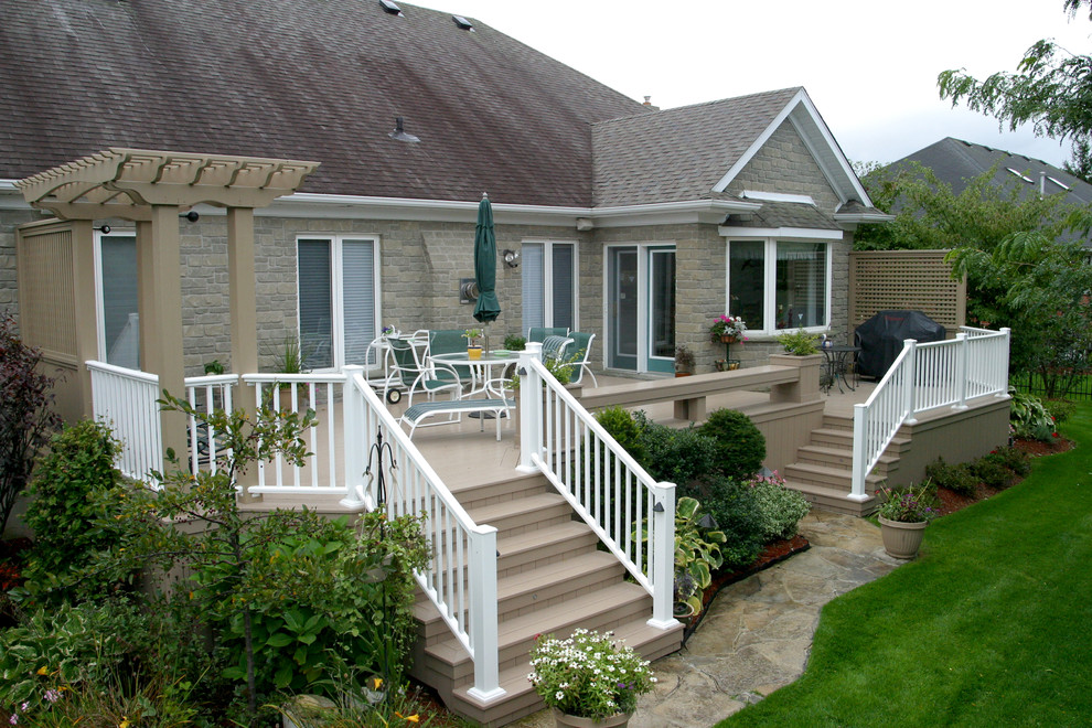 Example of a mid-sized minimalist backyard deck design in Toronto with no cover