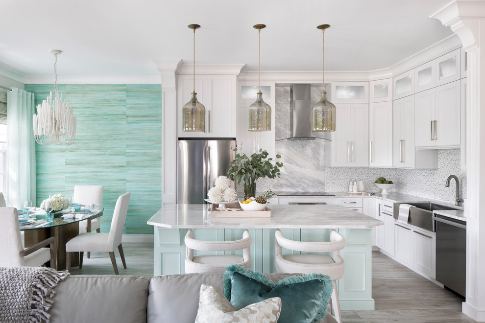 Design ideas for a small beach style l-shaped eat-in kitchen in Miami with a farmhouse sink, recessed-panel cabinets, white cabinets, quartzite benchtops, white splashback, marble splashback, stainless steel appliances, porcelain floors, with island, grey floor and grey benchtop.