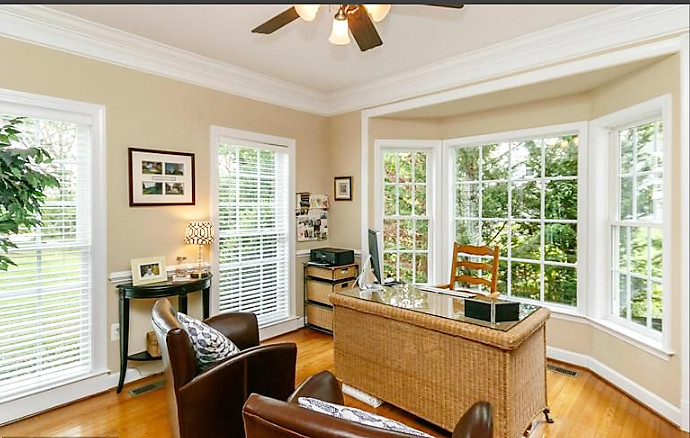 Large traditional study room in Baltimore with beige walls, medium hardwood floors, a freestanding desk and brown floor.