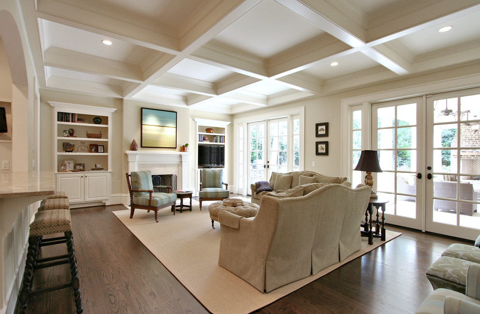 Design ideas for a traditional living room in Atlanta with beige walls, dark hardwood floors, a standard fireplace and brown floor.