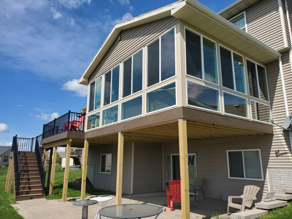 Deck - large backyard second story metal railing deck idea with a roof extension