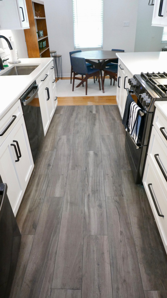 Eat-in kitchen - mid-sized transitional galley porcelain tile and gray floor eat-in kitchen idea with an undermount sink, shaker cabinets, white cabinets, quartz countertops, white backsplash, subway tile backsplash, black appliances, no island and white countertops