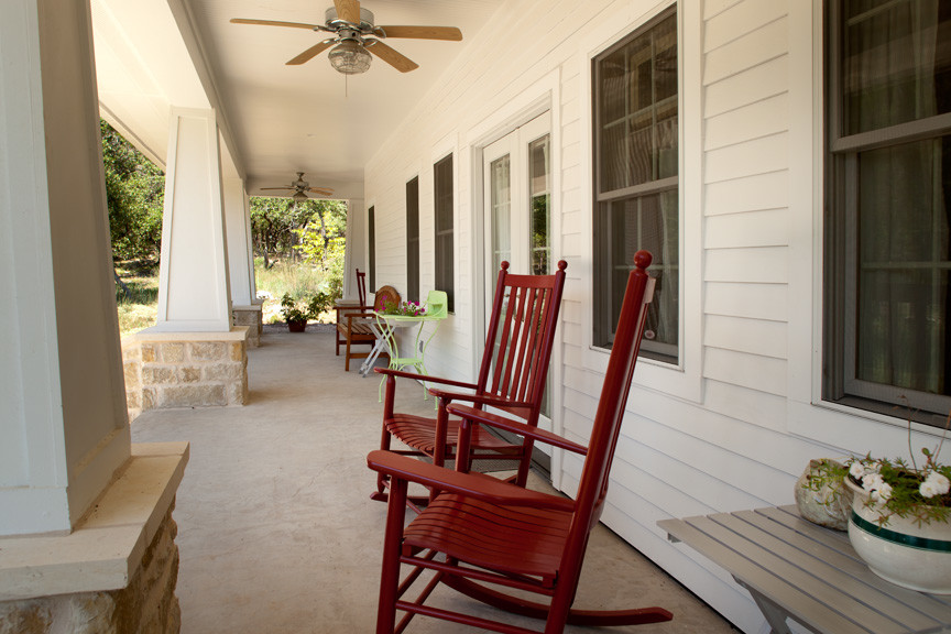 Mid-sized country front yard verandah in Austin with concrete slab and a roof extension.