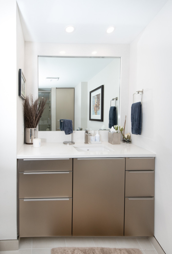This is an example of a medium sized contemporary ensuite bathroom in Miami with flat-panel cabinets, brown cabinets, an alcove shower, a two-piece toilet, beige tiles, porcelain tiles, white walls, porcelain flooring, a built-in sink, engineered stone worktops, white floors, a hinged door, white worktops, a shower bench, double sinks and a freestanding vanity unit.