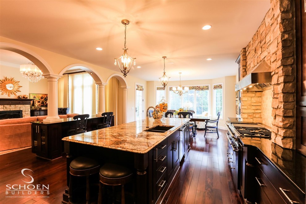 Inspiration for a large transitional u-shaped dark wood floor eat-in kitchen remodel with an undermount sink, recessed-panel cabinets, dark wood cabinets, granite countertops, beige backsplash, subway tile backsplash, colored appliances and two islands