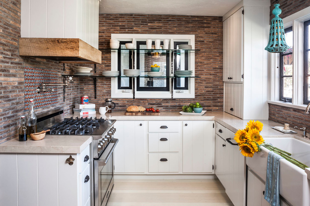 Photo of an eclectic u-shaped separate kitchen in Orange County with marble benchtops, a farmhouse sink, white cabinets, stainless steel appliances, multi-coloured splashback and beige benchtop.