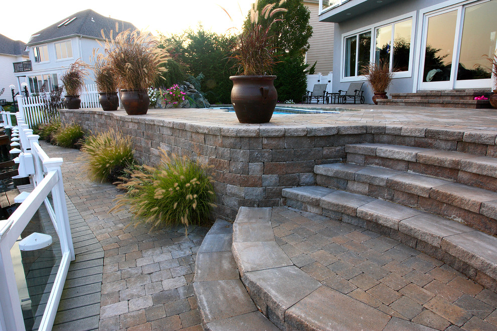 Mid-sized transitional backyard patio in New York with a water feature and brick pavers.